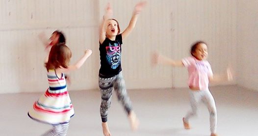 Image of children dancing with smiles and concentration