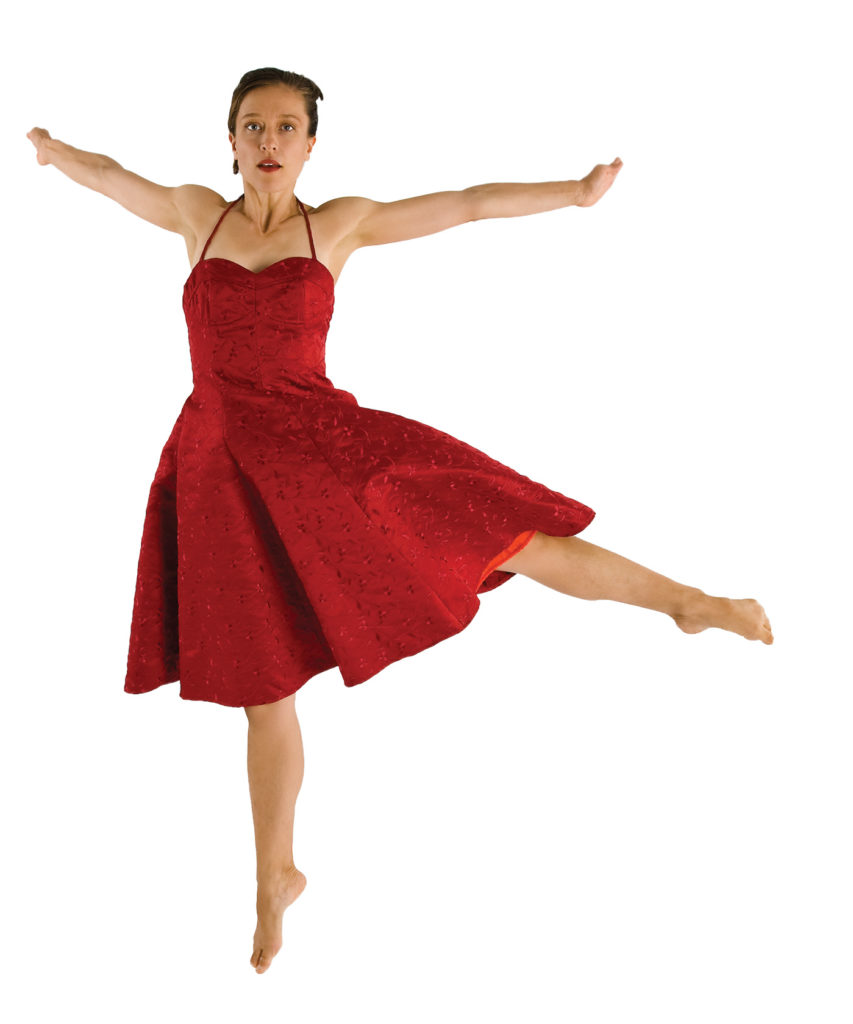 Jessica Runge jumps, legs and arms extended, in a red dress